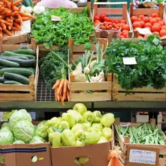Stoisko z warzywami: marchew, buraki, cukinie, pomidory, sałata, papryka, fasolka szparagowa, bakłażany. Chlorek wapnia jako nawóz wspiera wzrost tych zdrowych produktów.