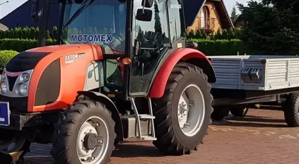 Czerwony traktor Zetor z przyczepą. Zastanawiasz się, ile kosztuje prawo jazdy na traktor?